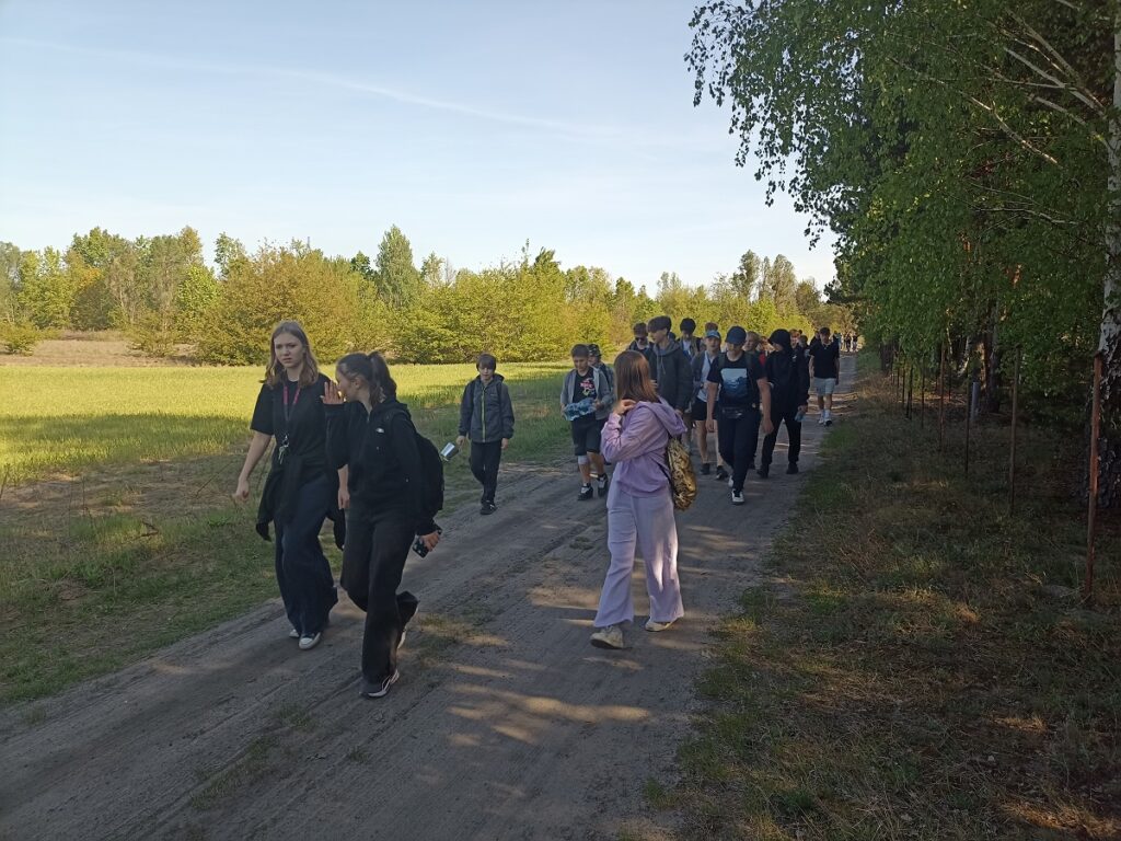 Grupa idących uczniów z PSP 3 Kozienice podczas rajdu pieszego do "Królewskich Źródeł"