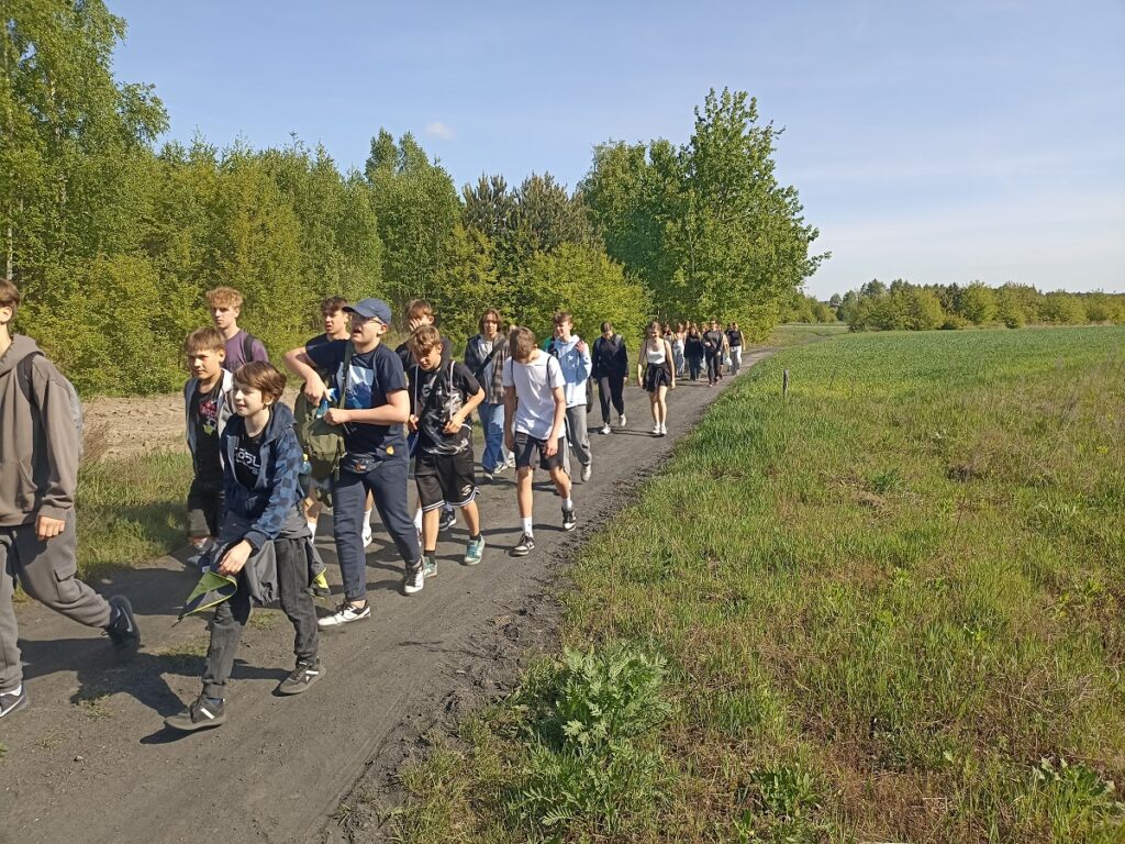 Grupa idących uczniów z PSP 3 Kozienice podczas rajdu pieszego do "Królewskich Źródeł"