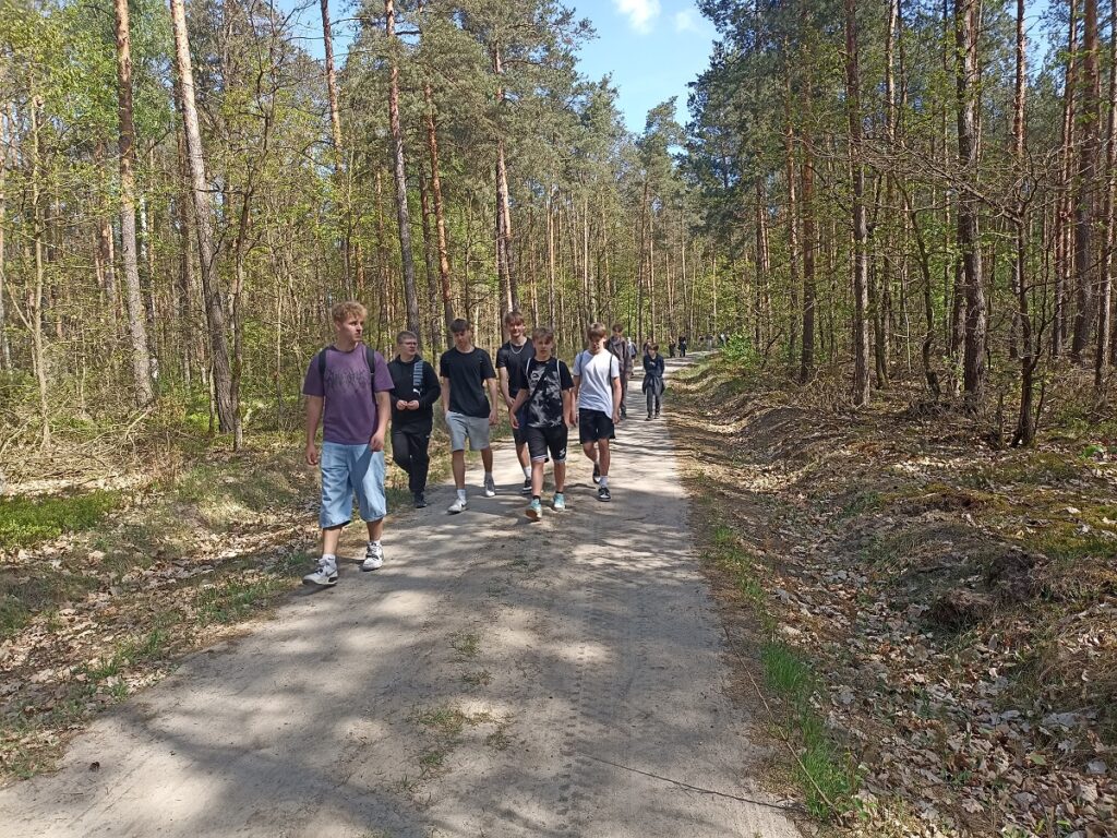 Grupa idących uczniów z PSP 3 Kozienice podczas rajdu pieszego do "Królewskich Źródeł"