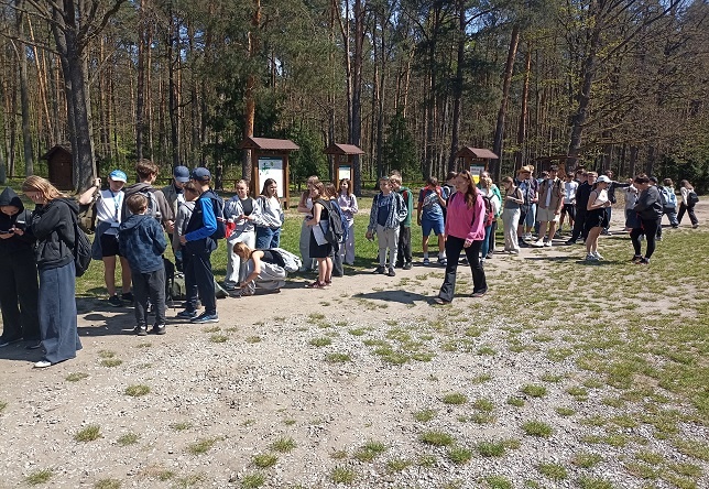 Grupa stojących uczniów z PSP 3 Kozienice na placu w lesie "Królewskie Źródła"