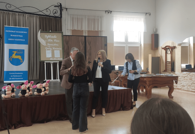 zdjęcie przedstawia uczennice odbierającą nagrodę