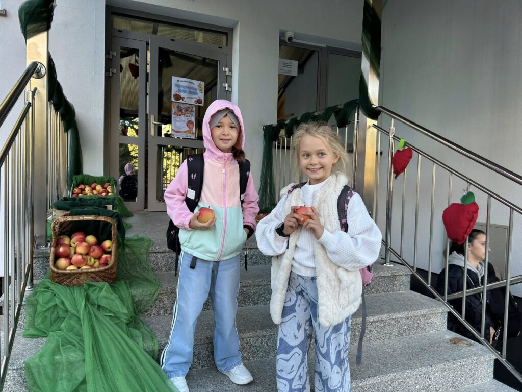 Dzieci stojące przed budynkiem szkoły