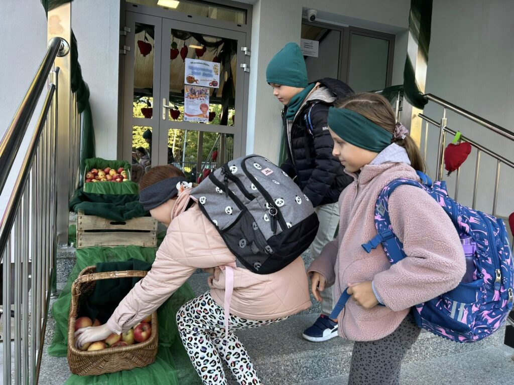 Dzieci stojące przed budynkiem szkoły