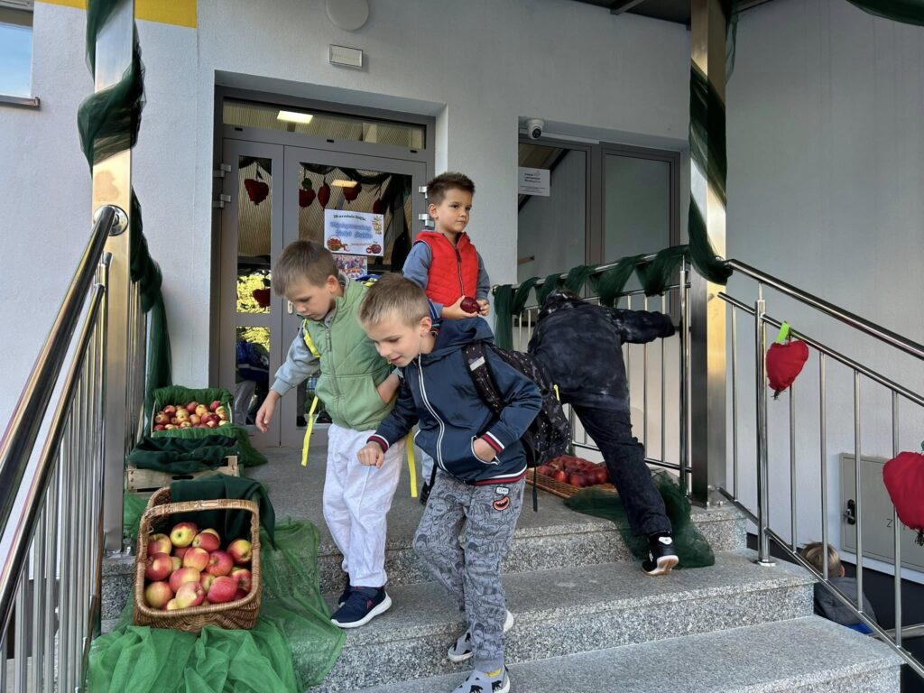 Dzieci stojące przed budynkiem szkoły