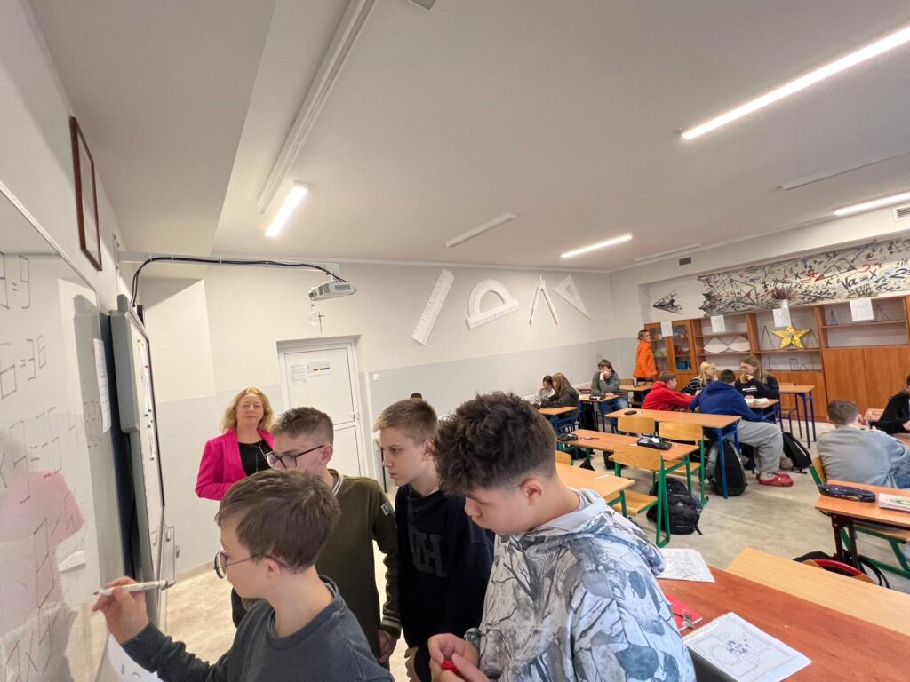 Uczniowie rozwiązujący rebusy matematyczne.