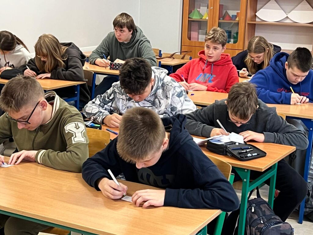 Uczniowie rozwiązujący rebusy matematyczne.