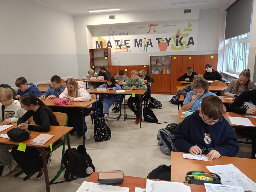 Uczniowie rozwiązujący rebusy matematyczne.