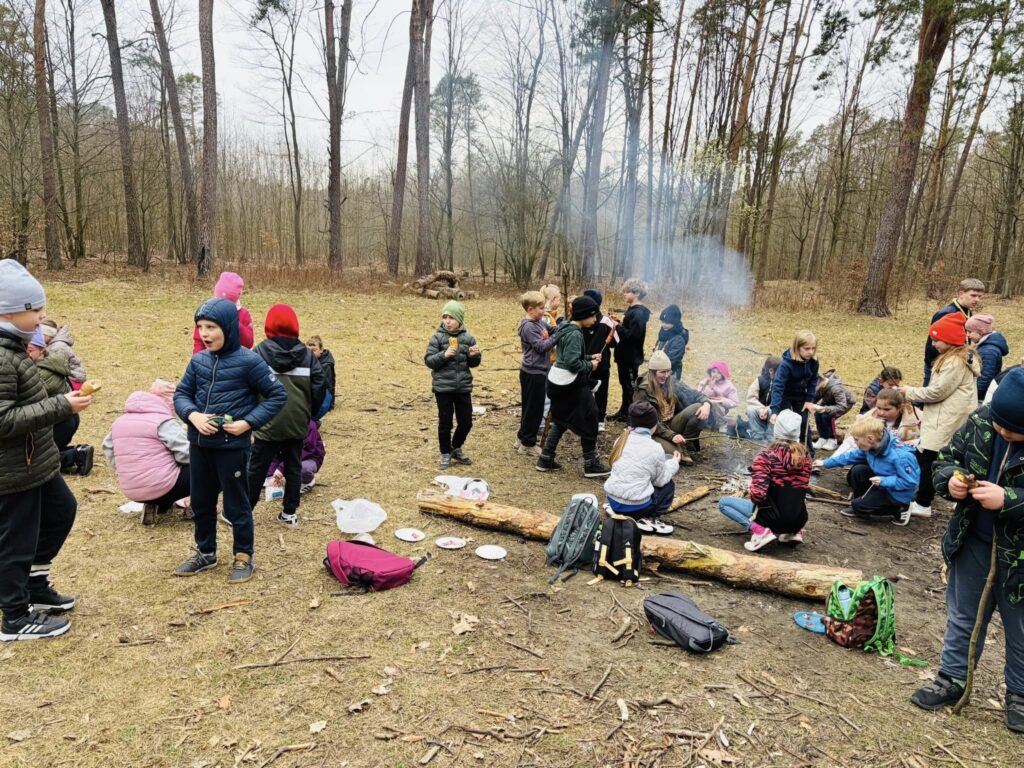 Uczniowie pieką kiełbaski przy ognisku